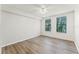 Well-lit bedroom showcasing hardwood floors, ceiling fan, and bright windows with blinds at 911 N Orange Ave # 321, Orlando, FL 32801