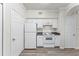 Kitchen with white appliances and cabinets, laminate countertops, and easy access to a doorway and closet at 911 N Orange Ave # 321, Orlando, FL 32801