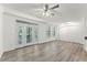 Bright living room featuring wood floors, ceiling fan, and access to balcony through glass doors at 911 N Orange Ave # 321, Orlando, FL 32801