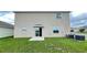 A lush green backyard featuring a sliding glass door and modern air conditioning unit at 1343 Lassen St, Haines City, FL 33844