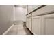 A well-lit bathroom featuring tile flooring, a tub with shower, and white cabinets at 1343 Lassen St, Haines City, FL 33844