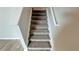 Carpeted staircase with white risers and handrail, leading to the next level of the home at 1343 Lassen St, Haines City, FL 33844