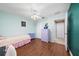 Well-lit bedroom featuring hardwood floors, white ceiling fan, and convenient access to storage and other rooms at 1405 Ashbury Ct, Lakeland, FL 33809