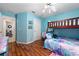 Well-lit bedroom featuring a bunk bed, wood-look floors, and two entryways at 1405 Ashbury Ct, Lakeland, FL 33809