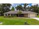 Charming single-story home with a well-manicured lawn and a two car garage at 1405 Ashbury Ct, Lakeland, FL 33809