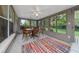 Enclosed sunroom with ample windows, a dining set, and a vibrant rug, perfect for enjoying outdoor views at 1405 Ashbury Ct, Lakeland, FL 33809