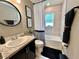Renovated bathroom featuring granite counters, black fixtures, a tub with shower and decorative shower curtain at 144 Foxtail Loop, Davenport, FL 33837
