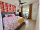 Bright bedroom featuring unique wallpaper, stylish bed, and a desk set up near a window with natural light at 144 Foxtail Loop, Davenport, FL 33837