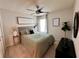 Well-lit bedroom with a decorative headboard, modern art, hardwood floors, and a cozy, inviting atmosphere at 144 Foxtail Loop, Davenport, FL 33837