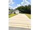 Long driveway leading up to a charming single-story home with a well-manicured lawn and a two-car garage at 144 Foxtail Loop, Davenport, FL 33837