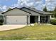 Charming single-story home with a well-manicured lawn and a two-car garage, showcasing inviting curb appeal at 144 Foxtail Loop, Davenport, FL 33837
