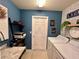 Spacious laundry room featuring blue walls, modern appliances, decorative shelving, and stylish accents at 144 Foxtail Loop, Davenport, FL 33837