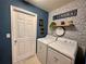 Well-organized laundry room with modern appliances, decorative wallpaper, and stylish signage for a cheerful space at 144 Foxtail Loop, Davenport, FL 33837