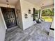 Inviting front porch with stylish tile flooring, modern lighting, and comfortable seating, perfect for relaxing outdoors at 144 Foxtail Loop, Davenport, FL 33837