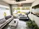 Bright sunroom with comfortable seating, workout equipment, TV, and views of the backyard patio and landscaping at 144 Foxtail Loop, Davenport, FL 33837