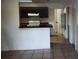 Kitchen with breakfast bar, tiled floor and dark cabinets at 2002 Cascades Blvd # 108, Kissimmee, FL 34741