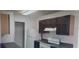 A partial kitchen view with dark wood cabinets, white appliances, and a breakfast bar at 2002 Cascades Blvd # 108, Kissimmee, FL 34741