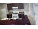 Kitchen with stainless steel sink, white appliances, dark wood cabinets and breakfast bar at 2002 Cascades Blvd # 108, Kissimmee, FL 34741