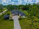 Stunning aerial view of a luxury home with a long driveway, lush landscaping, and a private setting at 20414 Quinn St, Orlando, FL 32833