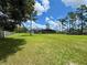 An expansive backyard features a well-manicured lawn with a screened in patio and a partial fence line at 20414 Quinn St, Orlando, FL 32833