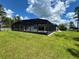 A large backyard features a pool with a screened-in enclosure and a manicured lawn at 20414 Quinn St, Orlando, FL 32833