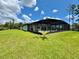A backyard features a pool with a screened-in enclosure on a large manicured lawn at 20414 Quinn St, Orlando, FL 32833