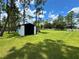 A backyard features a detached shed on a large manicured lawn at 20414 Quinn St, Orlando, FL 32833
