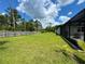 Expansive backyard with lush green lawn, mature trees, and a partial view of the home and screened patio at 20414 Quinn St, Orlando, FL 32833