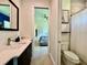 Bathroom featuring modern sink, toilet, and mirror, with doorway view into the bedroom at 20414 Quinn St, Orlando, FL 32833