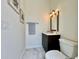 Cozy half bathroom with marble floors, framed wall art, and a dark vanity at 20414 Quinn St, Orlando, FL 32833