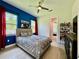 Stylish bedroom with blue accent wall, decorative headboard, and ample natural light at 20414 Quinn St, Orlando, FL 32833