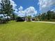 Beautiful home exterior with lush green lawn, mature trees, and a spacious driveway leading to the garage at 20414 Quinn St, Orlando, FL 32833