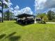 Beautiful home exterior with lush green lawn, mature trees, and a spacious carport at 20414 Quinn St, Orlando, FL 32833