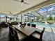 Outdoor dining area overlooks a screened pool, perfect for entertaining guests and enjoying the beautiful backyard at 20414 Quinn St, Orlando, FL 32833