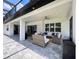 An outdoor patio features stone flooring and wicker furniture beneath a roof with a ceiling fan at 20414 Quinn St, Orlando, FL 32833