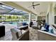Relaxing outdoor patio with comfortable seating overlooks the inviting screened pool and beautifully landscaped backyard at 20414 Quinn St, Orlando, FL 32833
