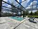 Outdoor screened in pool with hot tub, beautiful stone patio, and comfortable lounge seating at 20414 Quinn St, Orlando, FL 32833