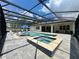 Beautiful screened pool with hot tub, blue umbrella, chaise lounge and chairs with lush landscaping at 20414 Quinn St, Orlando, FL 32833