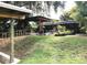 Sprawling backyard with mature trees, water access, covered seating, and lush lawn at 2082 Starboard Dr, Geneva, FL 32732