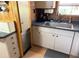 Compact kitchen showcases white cabinetry, a stainless steel dishwasher, and dark countertops at 2082 Starboard Dr, Geneva, FL 32732