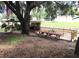 Backyard view with wooden picnic table, manicured lawn, boat house and waterfront access at 2082 Starboard Dr, Geneva, FL 32732