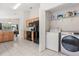 A kitchen with wood cabinets and black appliances along with laundry closet at 2263 Mallory Cir, Haines City, FL 33844