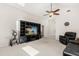 Bright living room with a high ceiling, neutral carpet, a ceiling fan, and entertainment center at 2263 Mallory Cir, Haines City, FL 33844