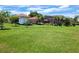 View of the large backyard with mature trees, lawn, and a screened-in pool at 2357 Great Harbor Dr, Kissimmee, FL 34746