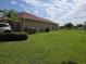 Spacious backyard with lush green grass, complemented by a palm tree and exterior of home at 2357 Great Harbor Dr, Kissimmee, FL 34746