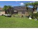 Spacious backyard featuring lush lawn, screened enclosure, and tropical palm trees at 2357 Great Harbor Dr, Kissimmee, FL 34746
