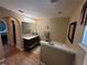 Bathroom featuring separate bath area, vanity with large mirror, wood-look tiled floors, and archway access at 2357 Great Harbor Dr, Kissimmee, FL 34746