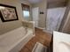 Bathroom featuring a soaking tub, patterned shower curtain and wood-look tiled floors at 2357 Great Harbor Dr, Kissimmee, FL 34746