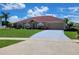 Charming single-story home features a red roof, two-car garage, manicured lawn, and mature landscaping at 2357 Great Harbor Dr, Kissimmee, FL 34746