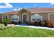 Inviting front entrance with well-maintained lawn, blooming bushes, and a decorative wreath on the green front door at 2357 Great Harbor Dr, Kissimmee, FL 34746